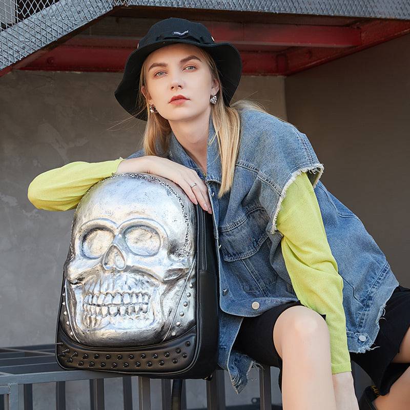 Unisex 3D skull backpack by Rossie Viren featuring a smiling skull design, studded accents, large capacity, ideal for laptops.