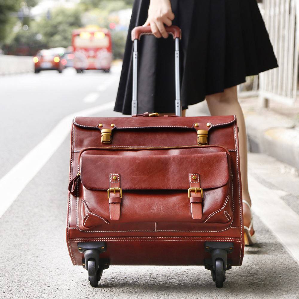 Vintage 20-inch vegetable tanned leather carry-on rolling suitcase with spinner wheels in brown, by Rossie Viren.