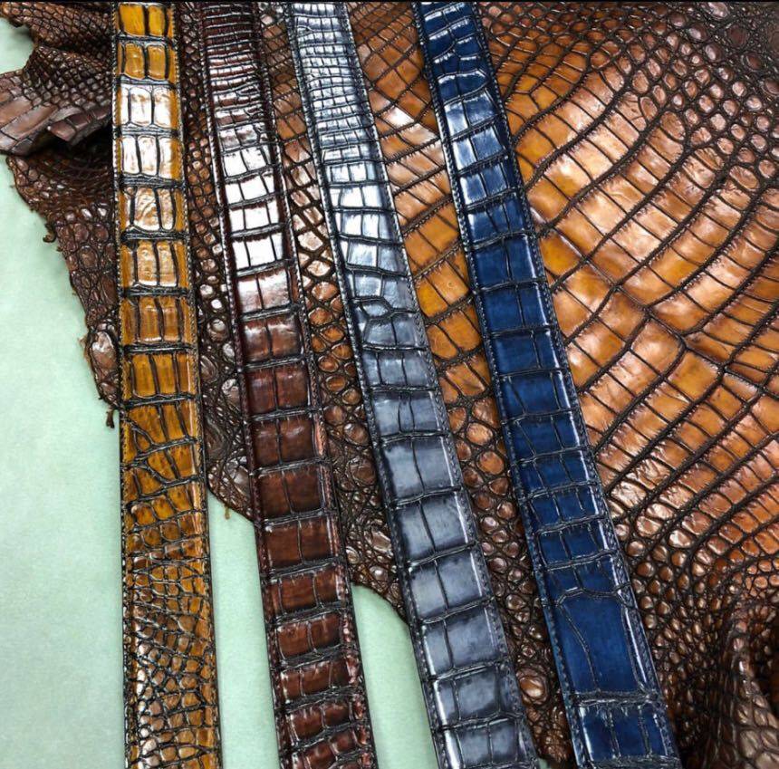 Rossie Viren grey crocodile skin leather belt with a classic buckle, showcasing textured crocodile pattern and sleek design.