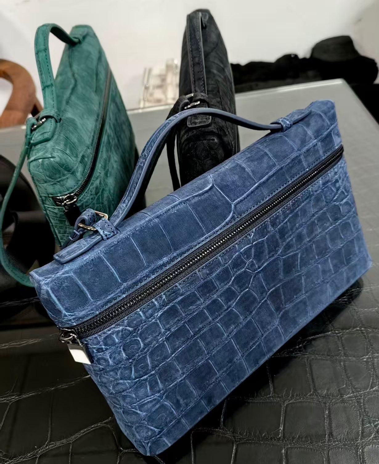 Blue unisex clutch bag with crocodile skin leather, zipper handle, by Rossie Viren, showcasing its textured genuine leather design.