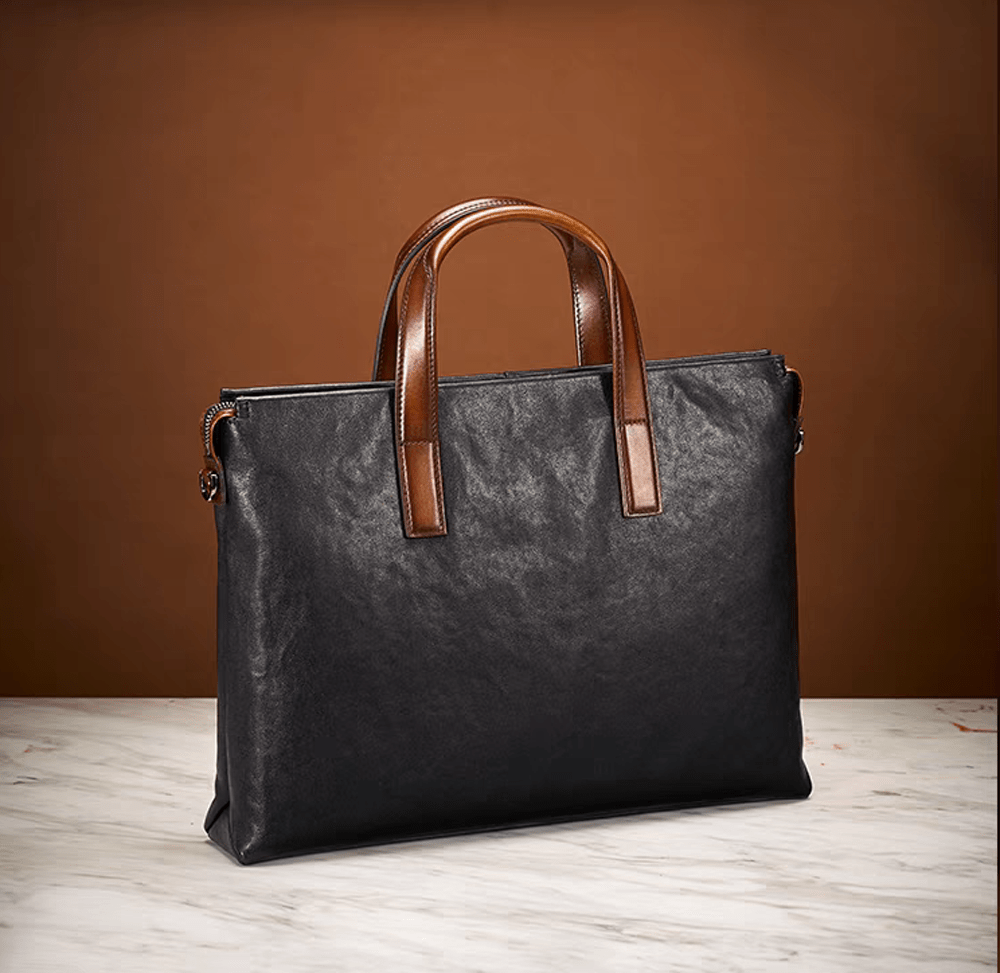 Black 15-inch Togo leather laptop briefcase bag by Rossie Viren, featuring a structured handbag design with sturdy handles.