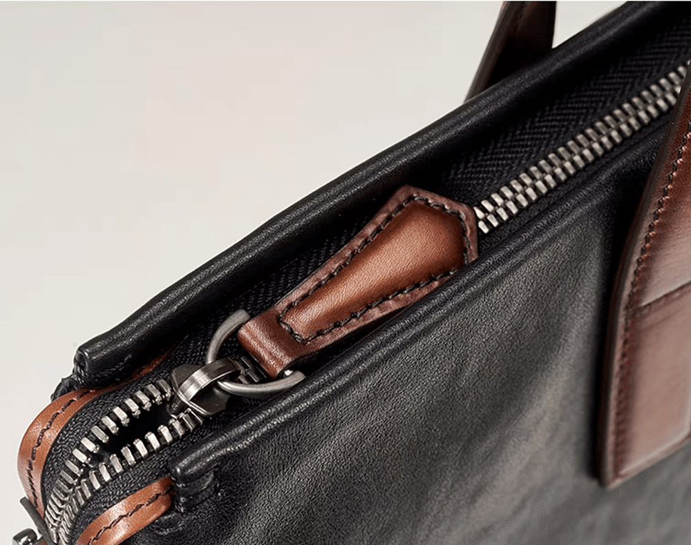 Black 15-inch Togo leather laptop briefcase bag by Rossie Viren, featuring a sleek handbag design with sturdy handles.