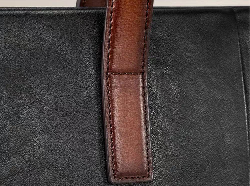 Black 15-inch Togo leather laptop briefcase bag by Rossie Viren, featuring a structured handbag design with handles and zipper closure.