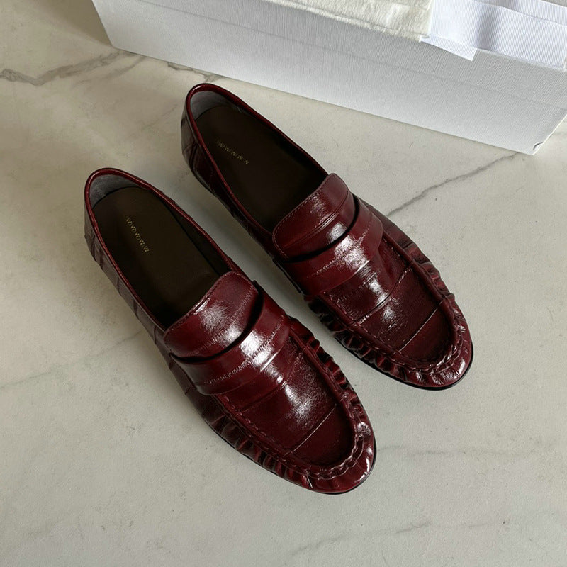 Eel skin loafers for women by Rossie Viren featuring sleek black shoes with a smooth finish and classic slip-on design.