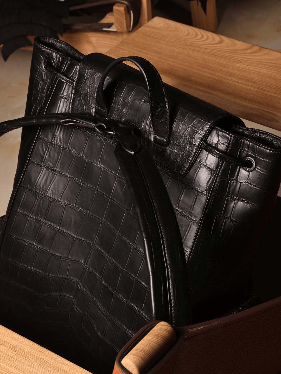 Unisex black crocodile leather backpack handbag with adjustable straps and silver hardware, designed by Rossie Viren.