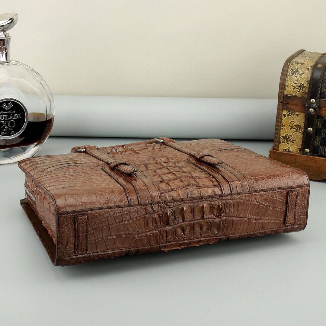 Rossie Viren crocodile leather briefcase in black and brown with sturdy handles and a sleek, professional handbag design.