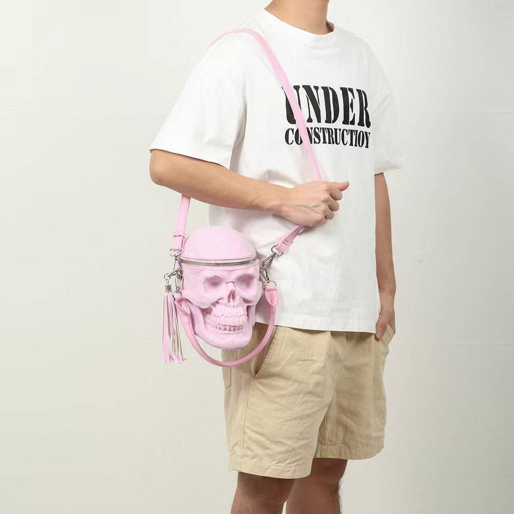 Pink suede 3D skull cross body handle bag by Rossie Viren, compact design with mini handle and shoulder strap.