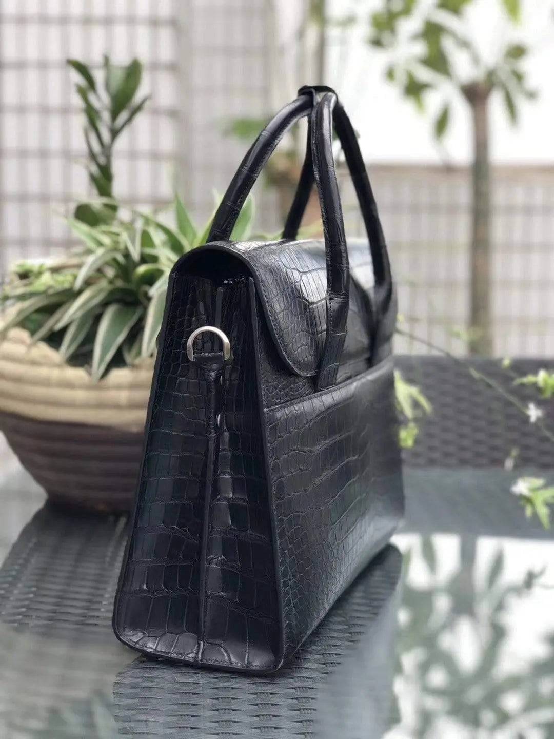 Black genuine crocodile leather foldover briefcase by Rossie Viren, featuring textured crocodile pattern and sturdy handle.