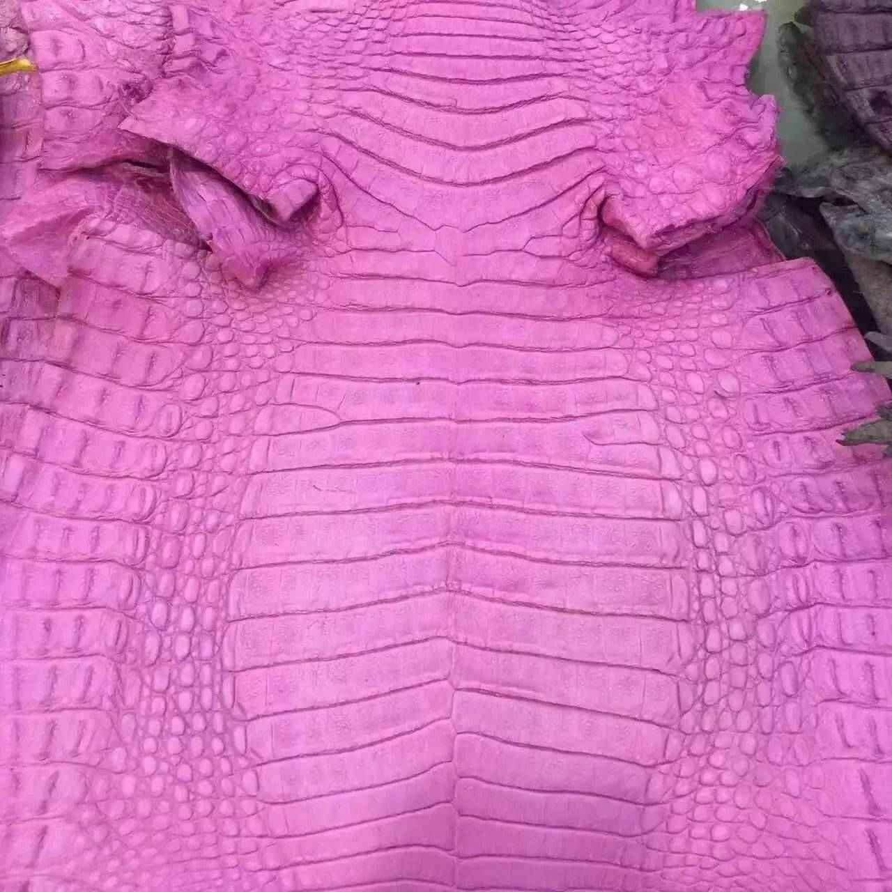 Close-up of crocodile belly leather in various colorways, showcasing the textured, luxurious exotic skin for handbags and belts.