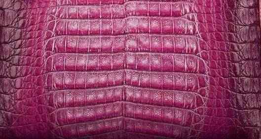 Close-up of crocodile belly leather in various colorways, showing textured crocodile skin pattern on the exotic leather bag.