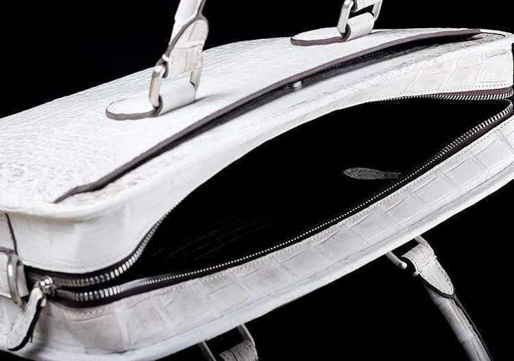 White crocodile belly leather briefcase handbag by Rossie Viren, featuring textured crocodile pattern and sturdy handle.