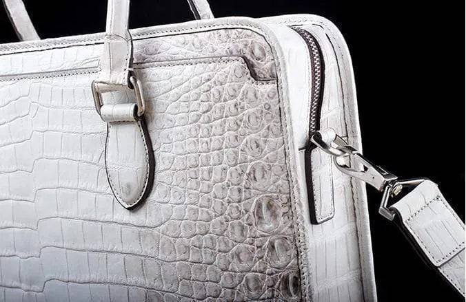 White crocodile belly leather briefcase handbag by Rossie Viren with textured crocodile pattern and sturdy handle.