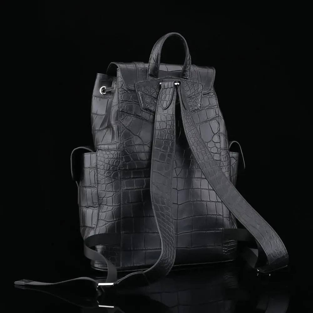 Black crocodile leather backpack by Rossie Viren with adjustable straps and a sleek, textured crocodile pattern.