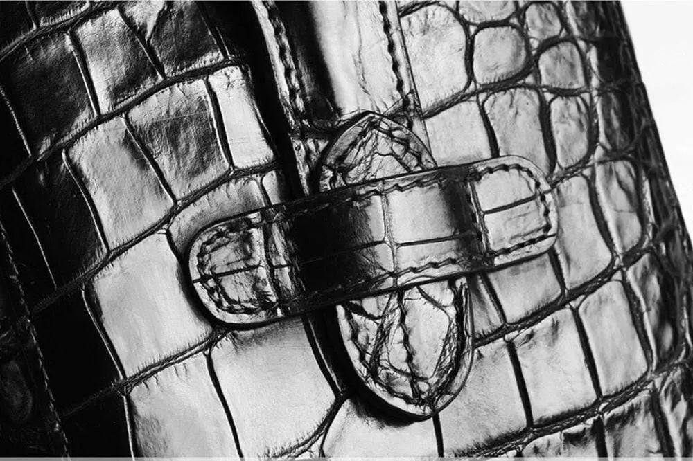 Rossie Viren crocodile leather city backpack handbag with sleek design and top handle, featuring textured crocodile pattern on front.