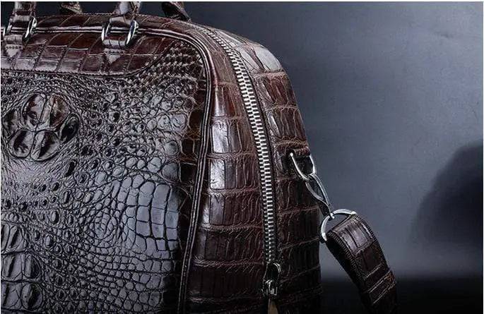 Brown crocodile leather duffel travel bag by Rossie Viren, featuring sturdy handles and spacious interior for travel essentials.