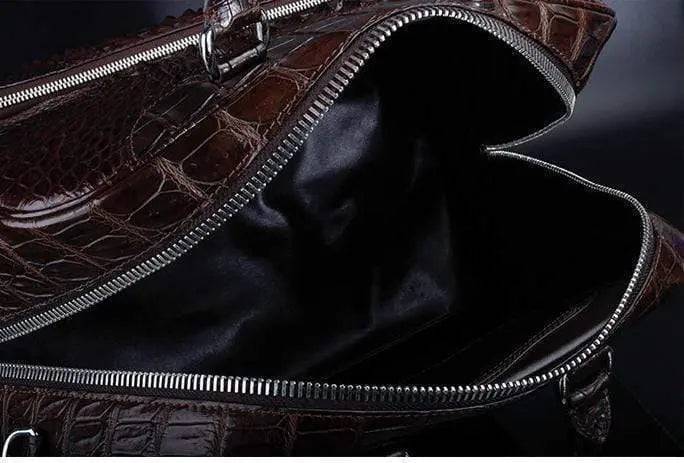 Brown crocodile leather duffel travel bag by Rossie Viren, featuring sturdy handles and a spacious design for travel essentials.