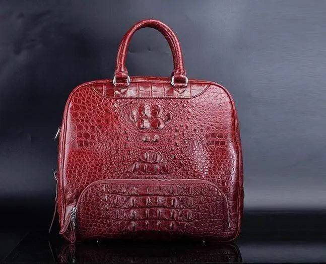 Red crocodile leather duffel travel bag by Rossie Viren, showcasing sturdy handles and sleek design.