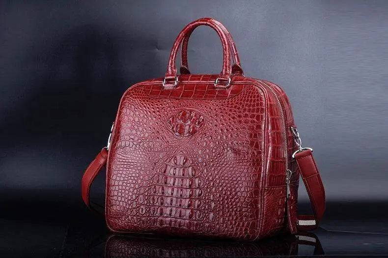 Red crocodile leather duffel travel bag by Rossie Viren, showing the textured crocodile skin and sturdy handles.