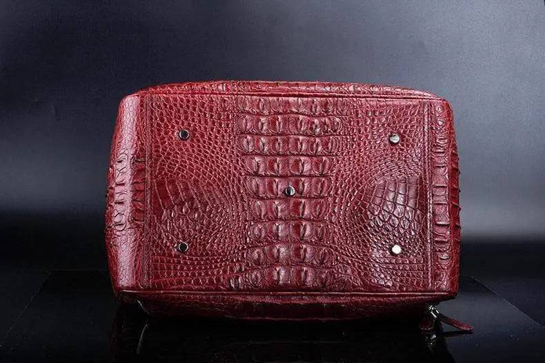 Red crocodile leather duffel travel bag by Rossie Viren, showcasing a spacious handbag with textured crocodile pattern and sturdy handles.