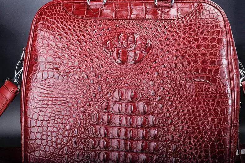 Red crocodile leather duffel travel bag by Rossie Viren, showing the textured crocodile skin and sturdy handles.