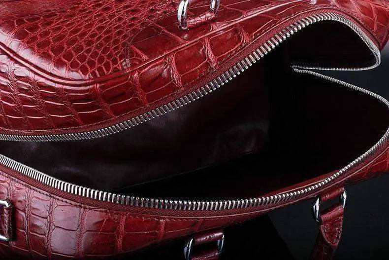 Red crocodile leather duffel travel bag by Rossie Viren with sturdy handles and a spacious main compartment.