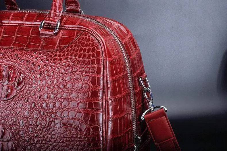 Red crocodile leather duffel travel bag by Rossie Viren, featuring sturdy handles and a spacious design for travel essentials.