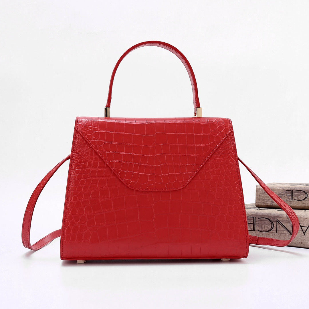 Red genuine crocodile skin leather top handle bag by Rossie Viren, featuring a sleek design and polished top handle.