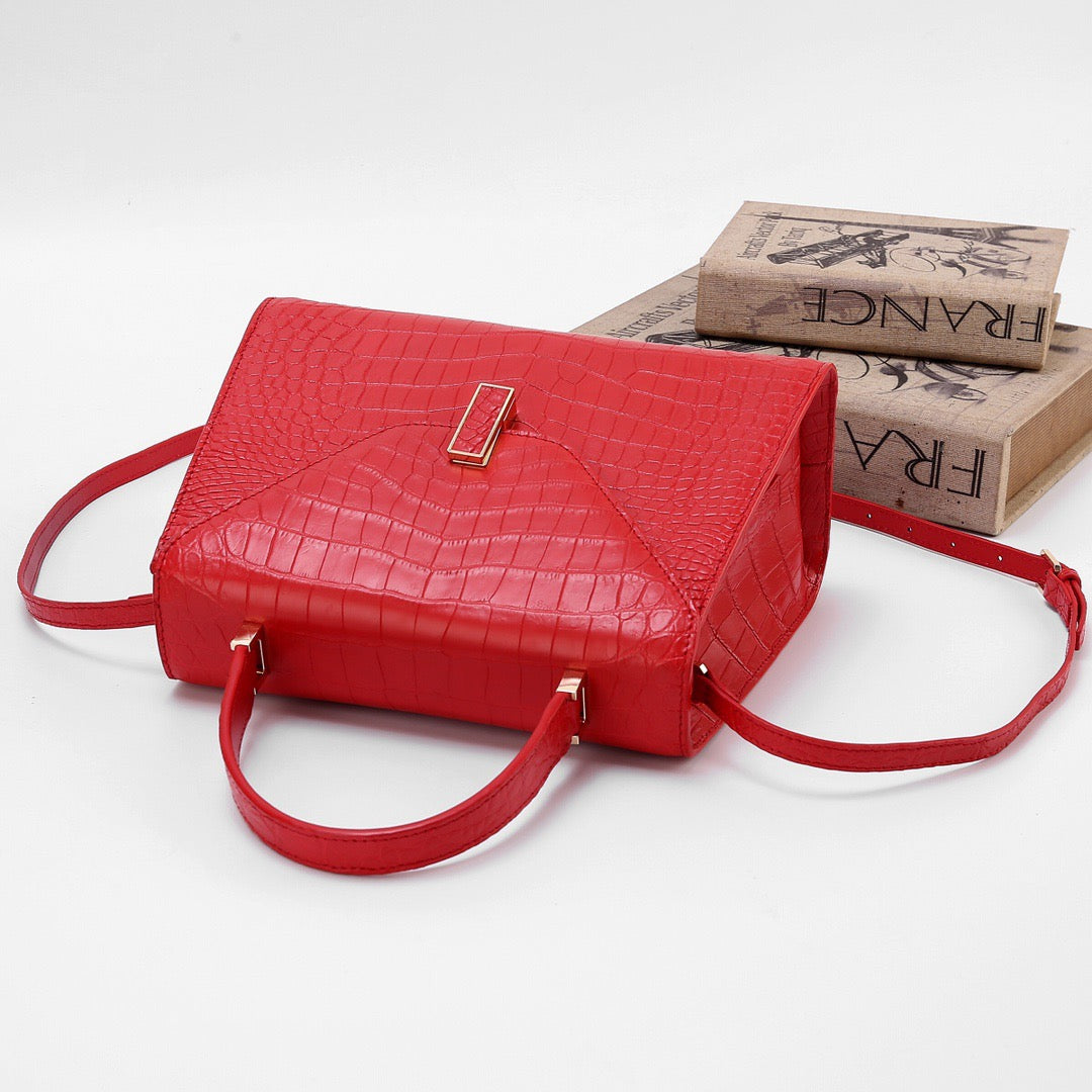 Red genuine crocodile skin leather top handle bag by Rossie Viren with a sleek design and sturdy handle.