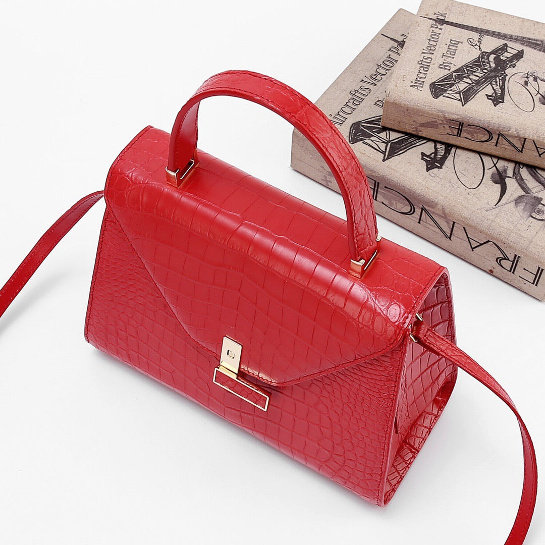 Red genuine crocodile skin leather top handle bag by Rossie Viren with a structured design and sturdy top handle.