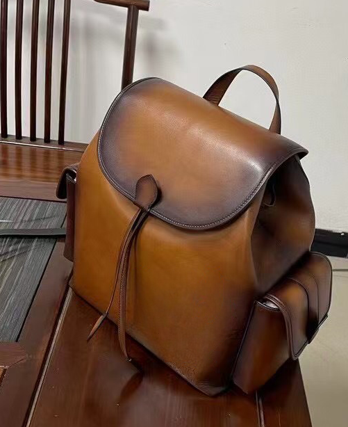 Vintage leather Rossie Viren handbag with adjustable shoulder straps and antique brass hardware, displayed against a neutral background.
