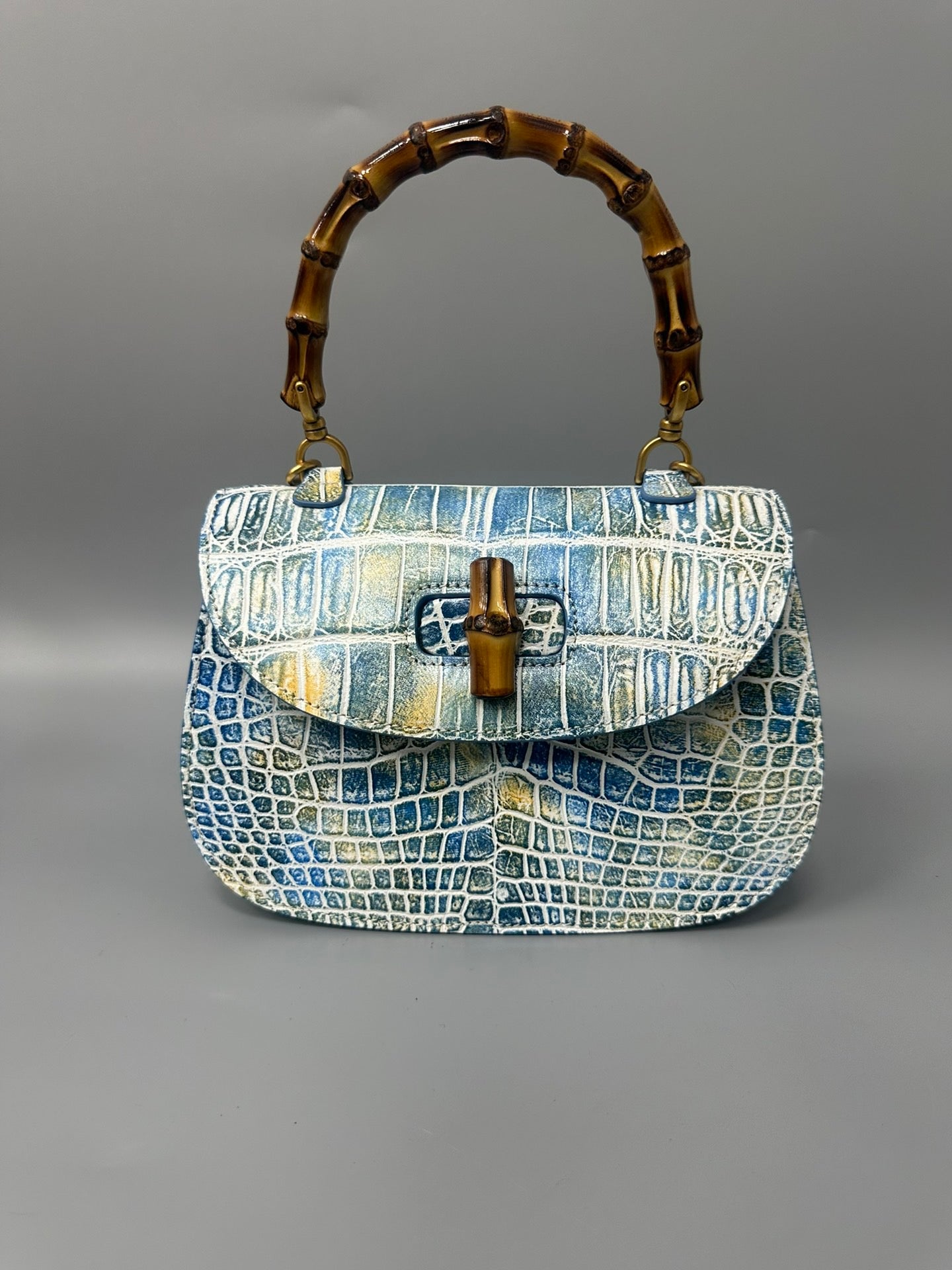 Brushed crocodile skin leather bamboo top handle crossbody bag by Rossie Viren with elegant design and textured finish.