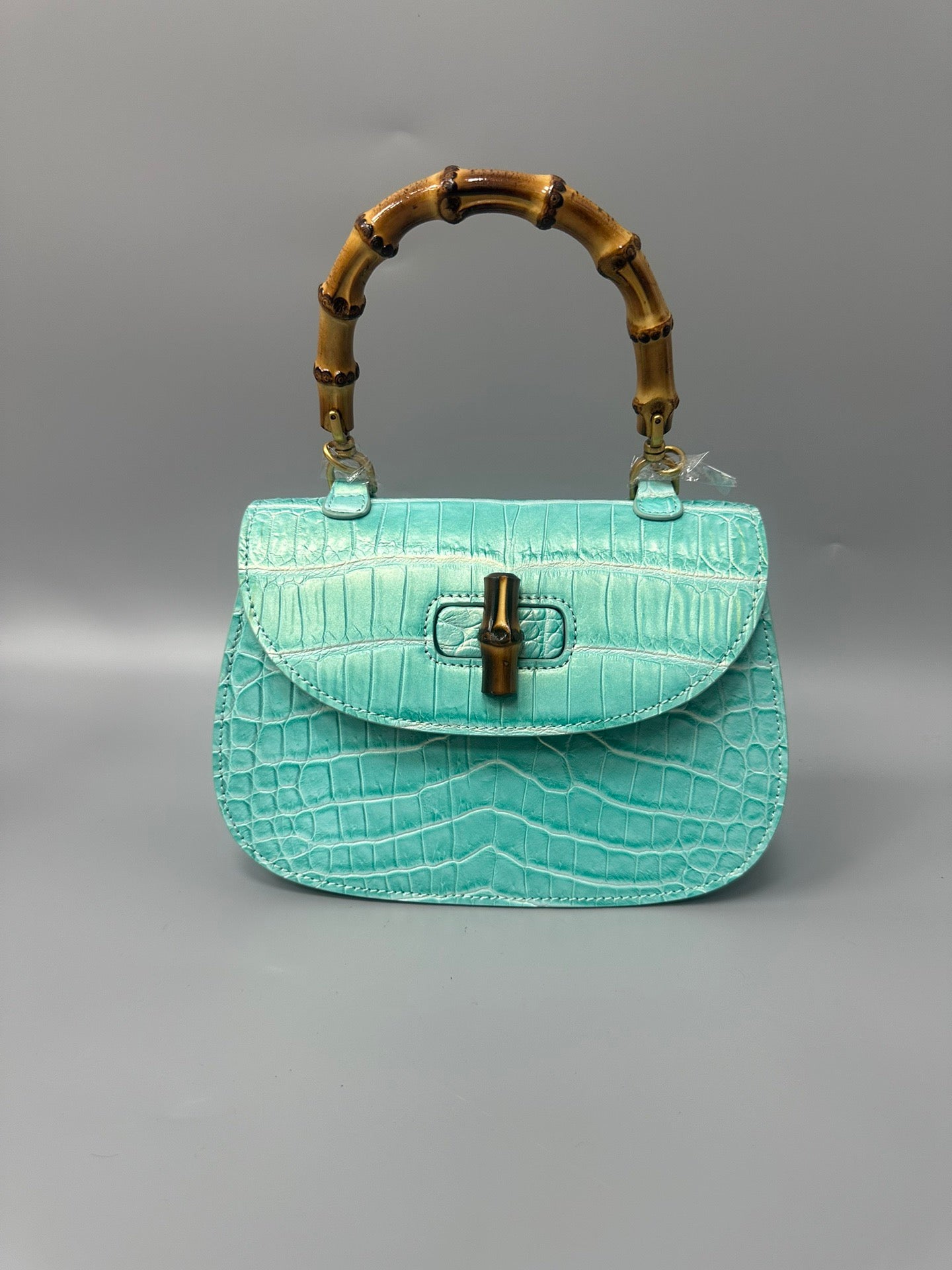 Rossie Viren brushed crocodile skin leather crossbody handbag with bamboo top handle, showcasing elegant craftsmanship and texture.
