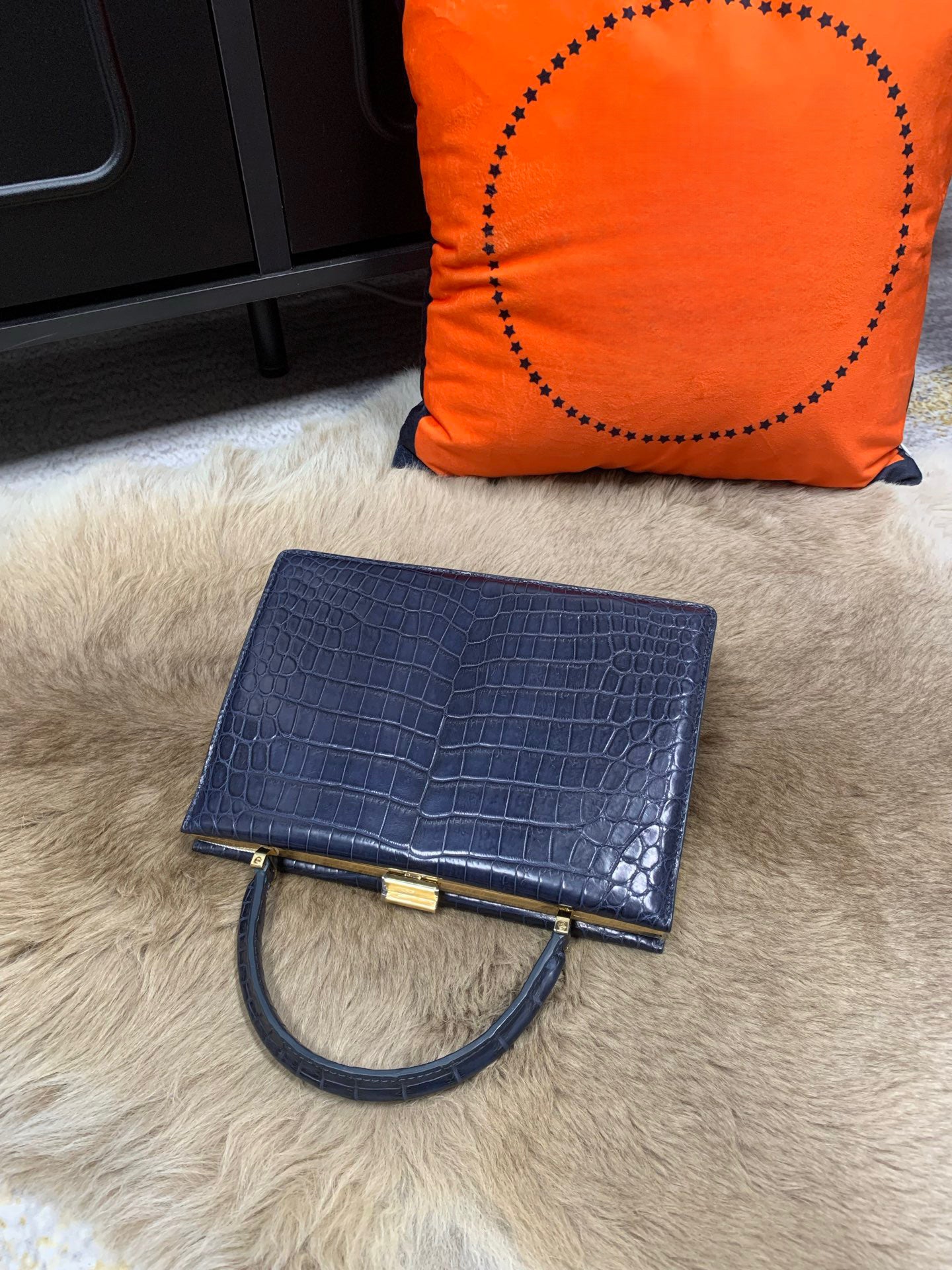 Rossie Viren crocodile leather evening clutch bag with top handle, showcasing a sleek, luxurious handbag design.