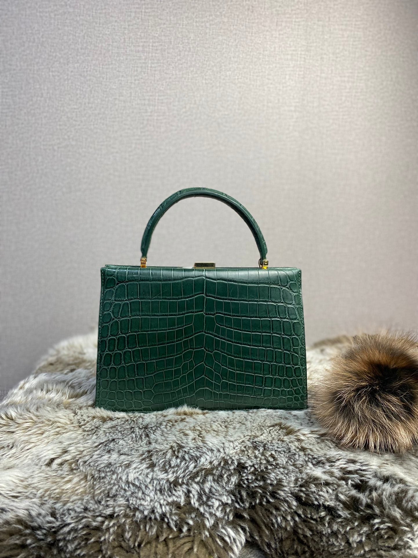 Rossie Viren crocodile leather evening clutch bag with top handle, showcasing its sleek design and textured finish.