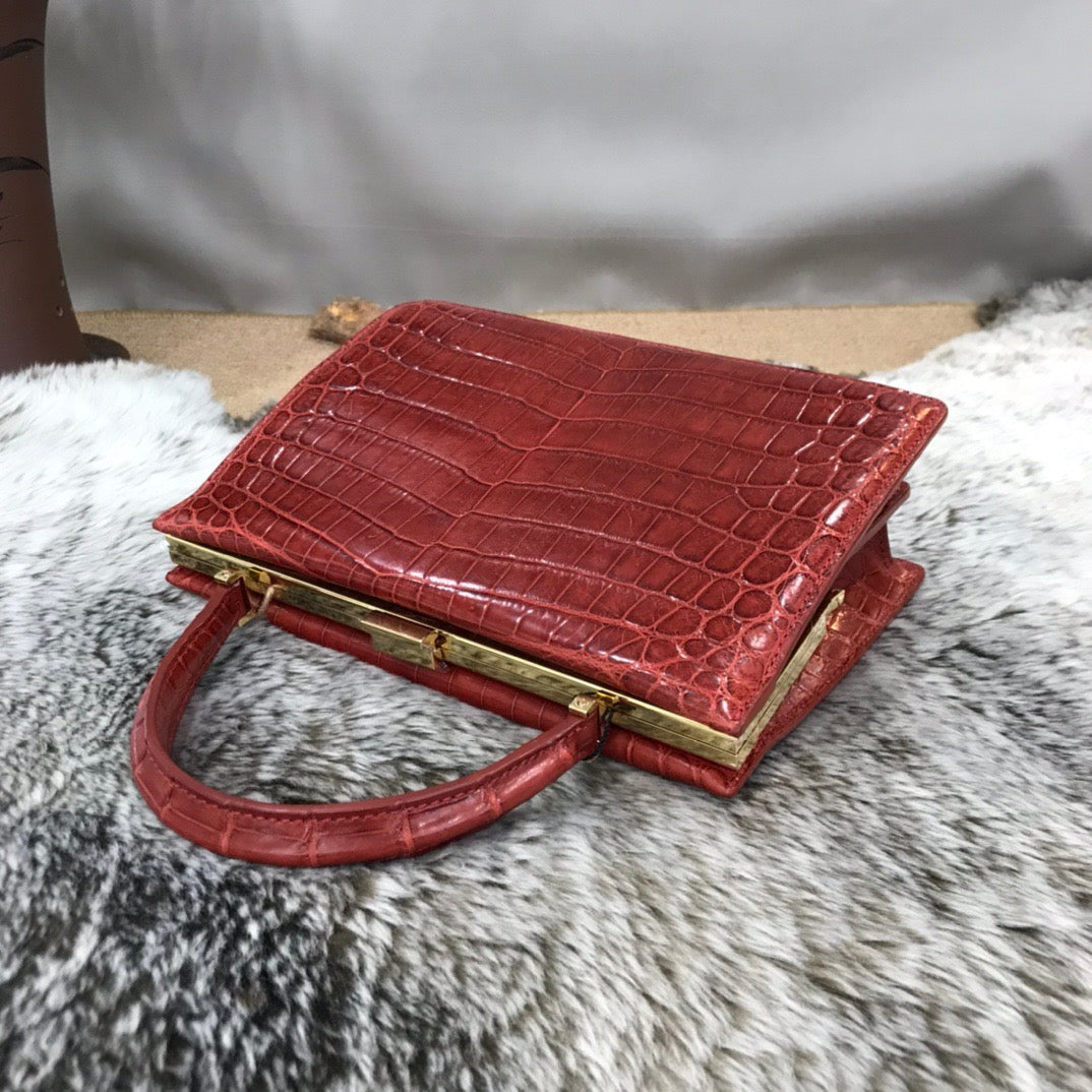 Rossie Viren crocodile leather evening clutch bag with top handle, showcasing a sleek and stylish handbag for special occasions.