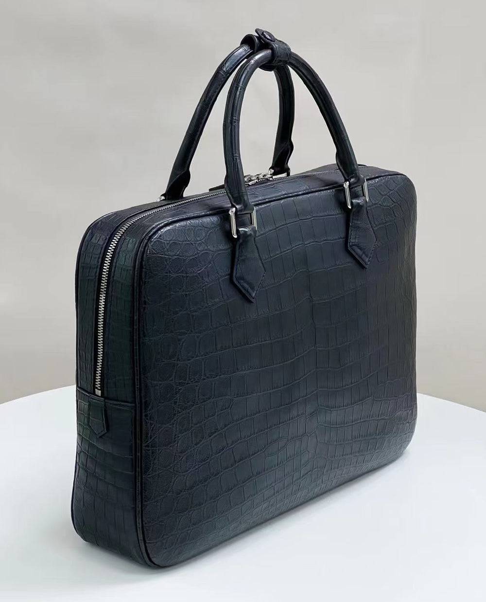 Genuine crocodile skin leather briefcase by Rossie Viren, showcasing a sleek, textured handbag with sturdy handles and metal accents.