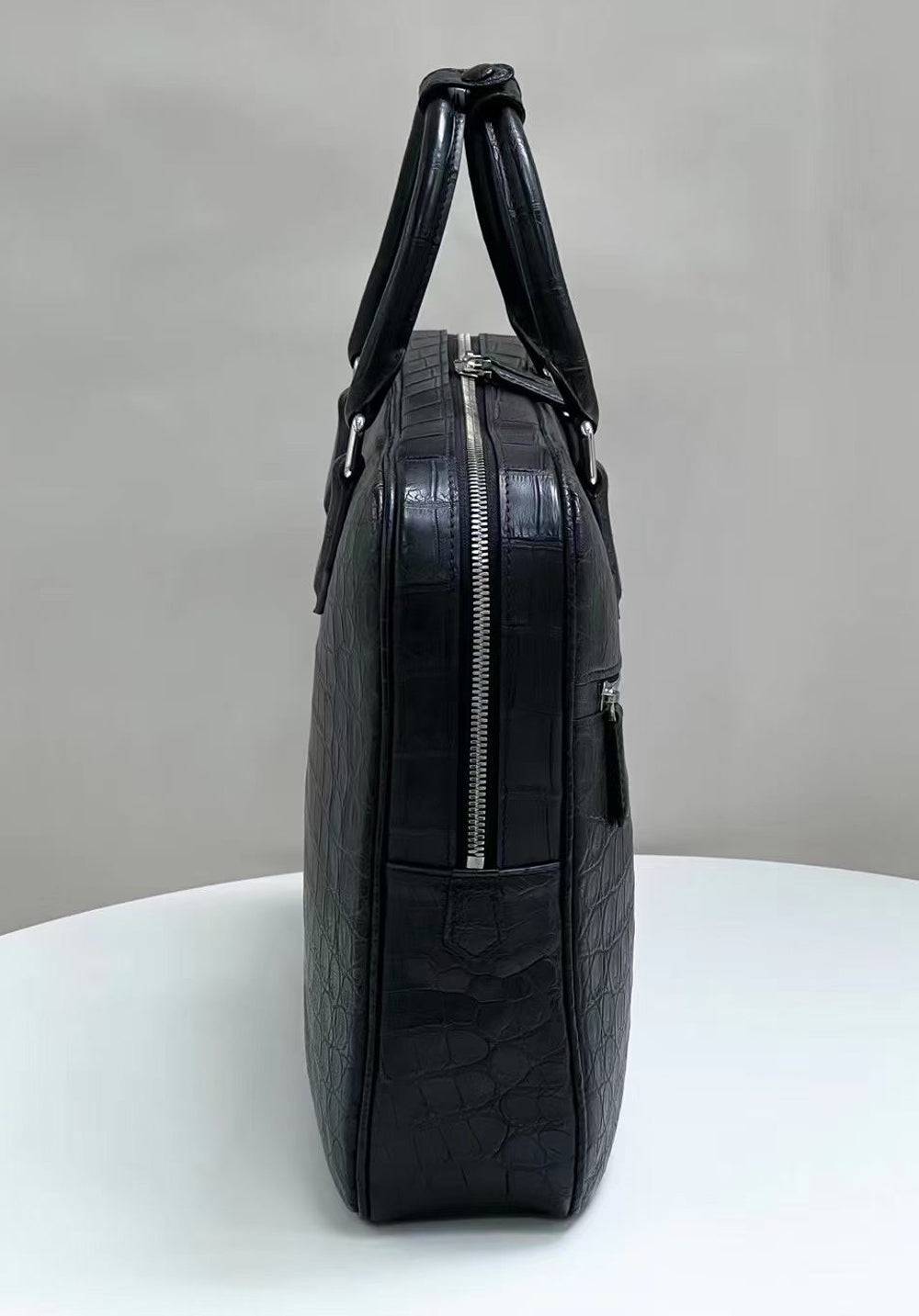 Genuine crocodile skin leather briefcase by Rossie Viren, showcasing a luxurious handbag with sleek design and detailed texture.