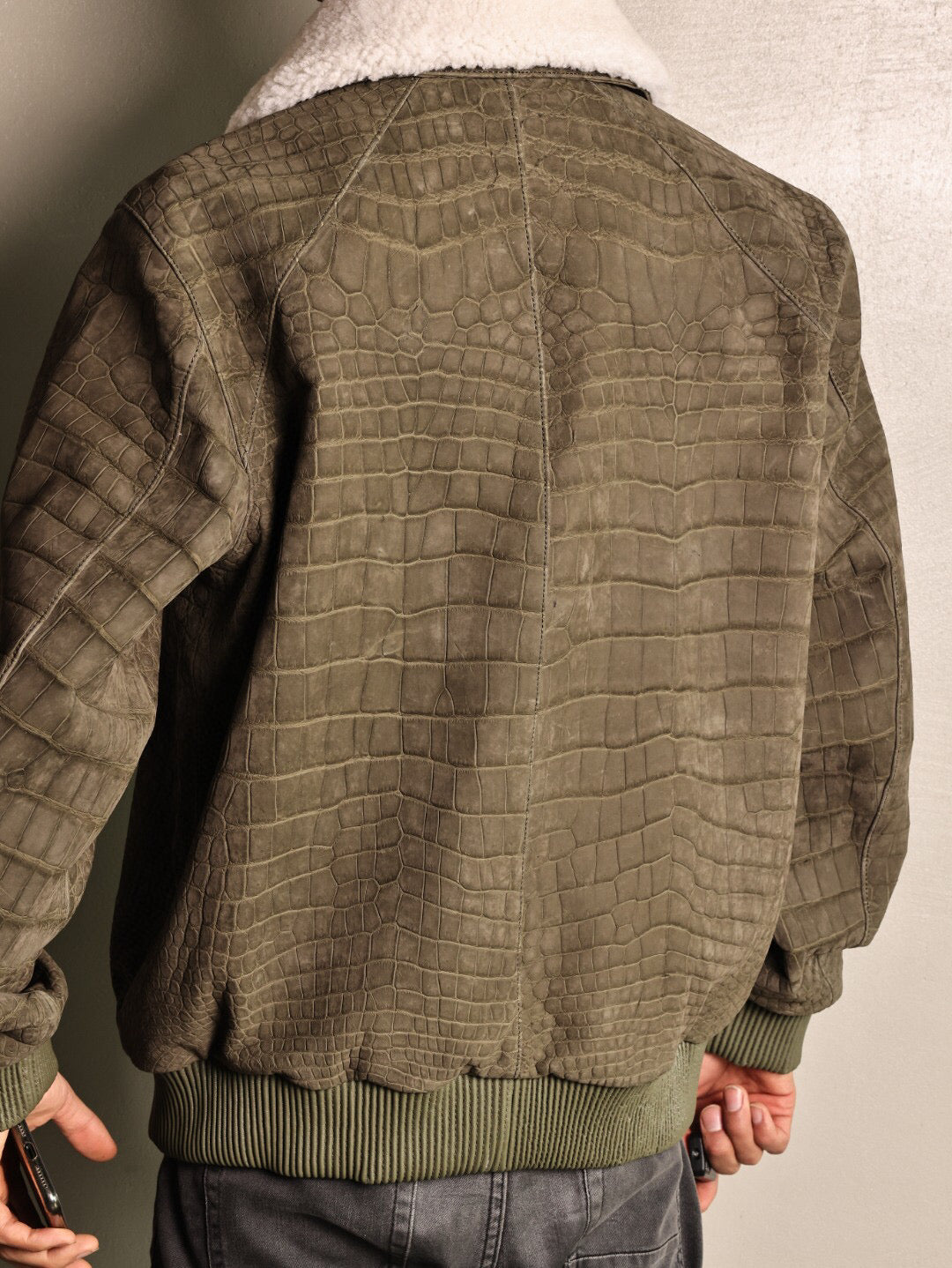 Green crocodile leather jacket with wool collar and zip-up front by Rossie Viren, casual coat with rat tail detail.