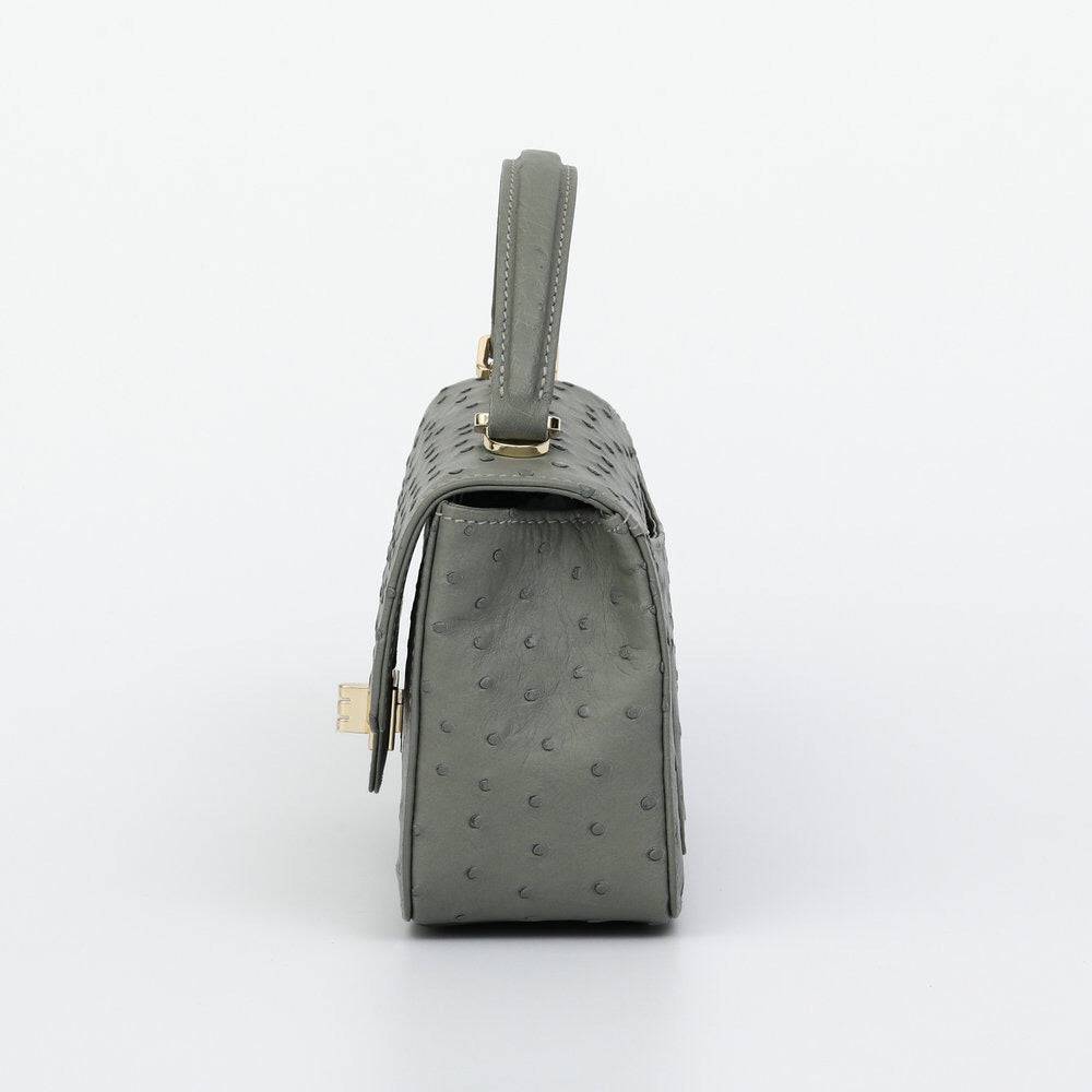 Women's ostrich leather mini flap chain handbag with top handle and crossbody strap by Rossie Viren, showing the bag's textured surface.