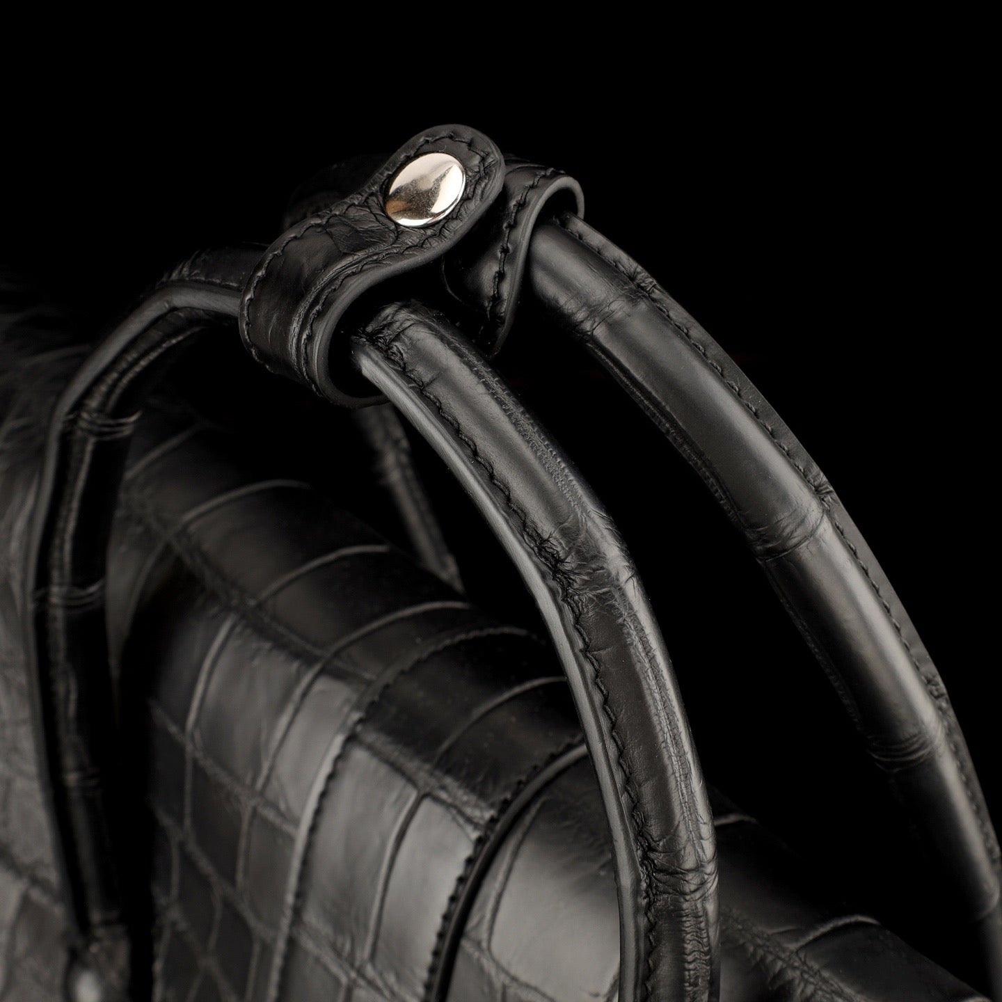 Black crocodile leather briefcase by Rossie Viren, featuring a sleek design with sturdy handles and metal clasps.
