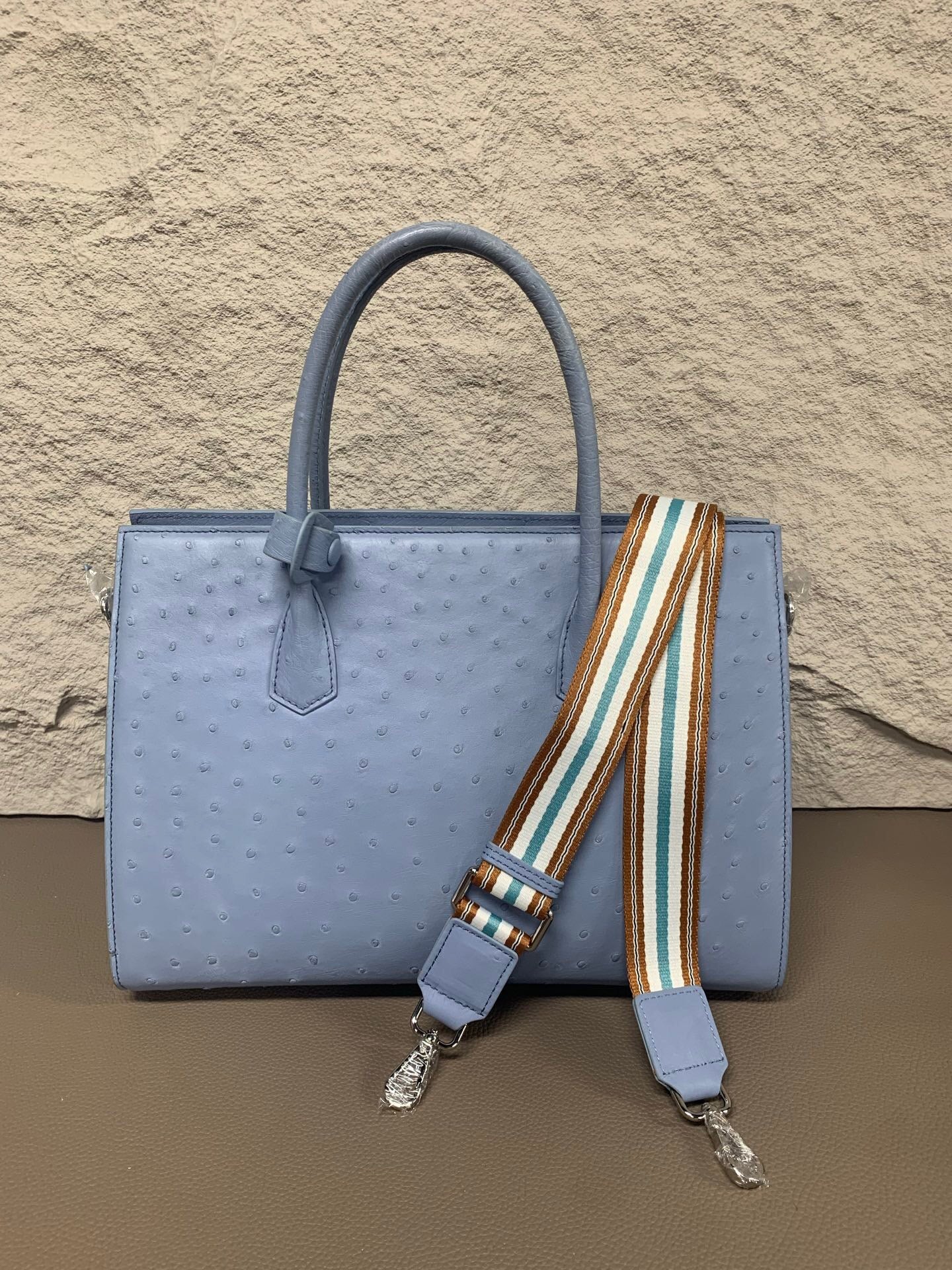 Rossie Viren women's ostrich skin leather handbag with top handle, showcasing textured black leather and elegant design.