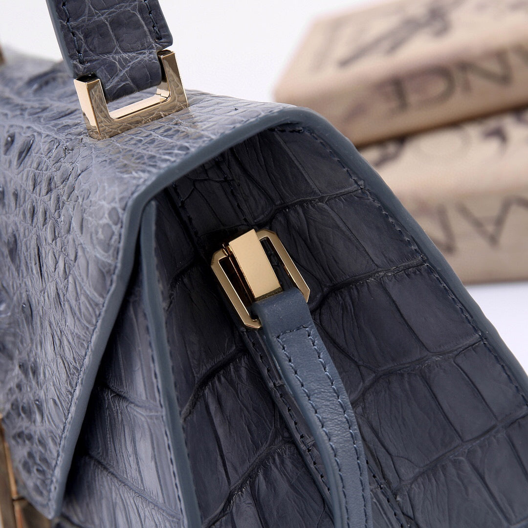 Grey genuine crocodile skin bone leather top handle bag by Rossie Viren with structured design and top handle, showcasing luxurious texture.