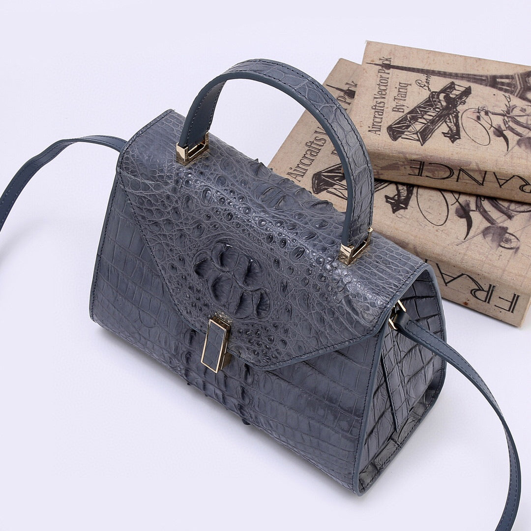 Genuine grey crocodile skin bone leather top handle bag by Rossie Viren with a structured design and top handle for stylish carrying.