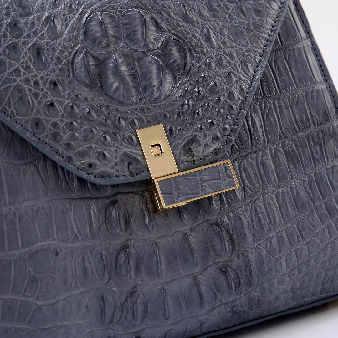 Genuine grey crocodile skin leather top handle bag by Rossie Viren with sleek design and sturdy handle.