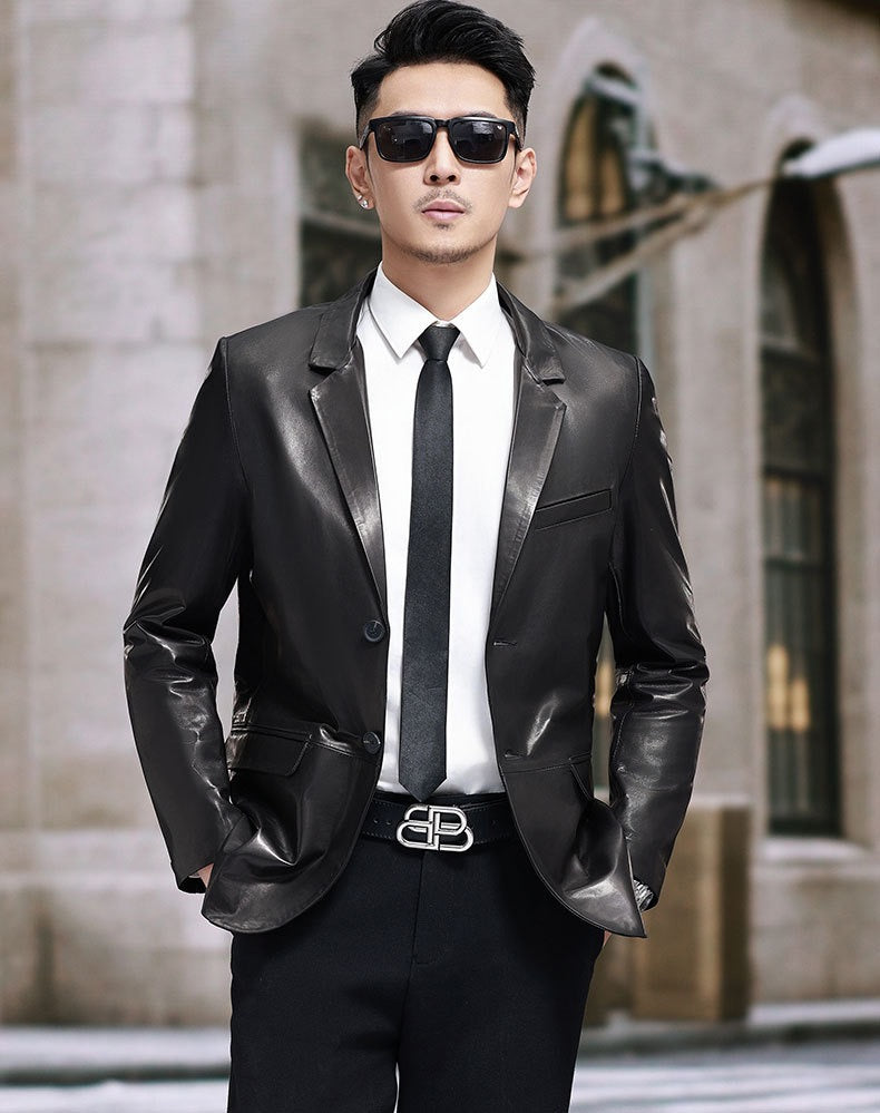 Black leather blazer jacket by Rossie Viren, tailored fit with lapel collar and button closure, shown on a hanger.