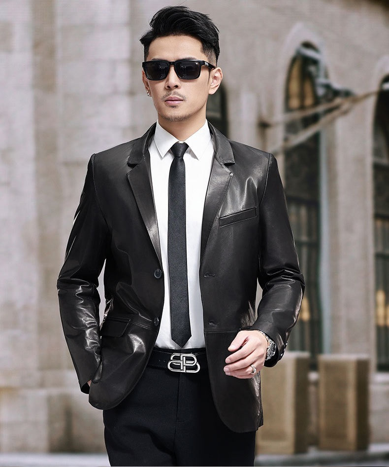 Black leather blazer jacket by Rossie Viren, featuring a tailored fit and classic design, shown hanging on a wooden hanger.