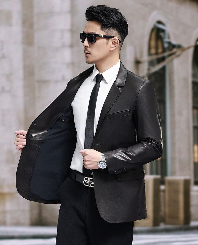 Black leather blazer jacket by Rossie Viren, tailored fit with lapels and button closure, displayed on a hanger.