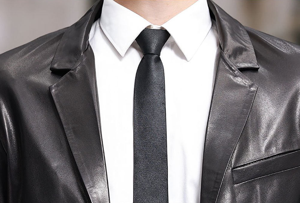 Black leather blazer jacket by Rossie Viren, featuring a tailored fit and classic design, shown on a hanger.