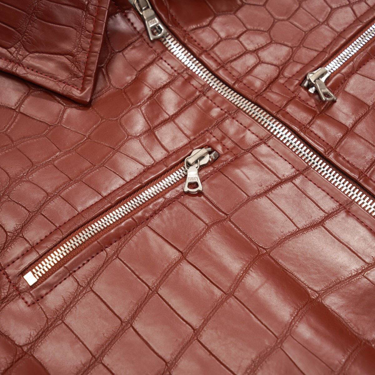 Red crocodile leather jacket by Rossie Viren with zip-up front, slim fit, casual trucker style, shown on a hanger.