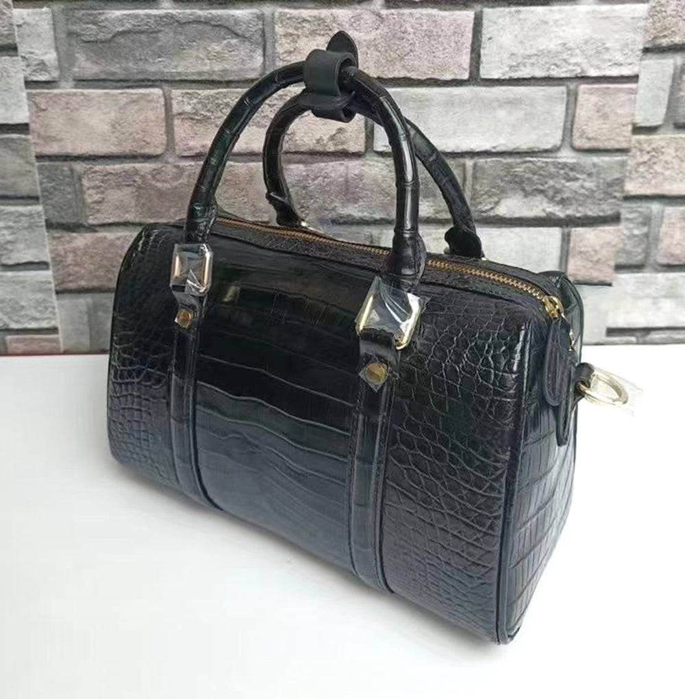 Black crocodile leather top handle Boston crossbody handbag by Rossie Viren with gold-tone hardware and structured design.